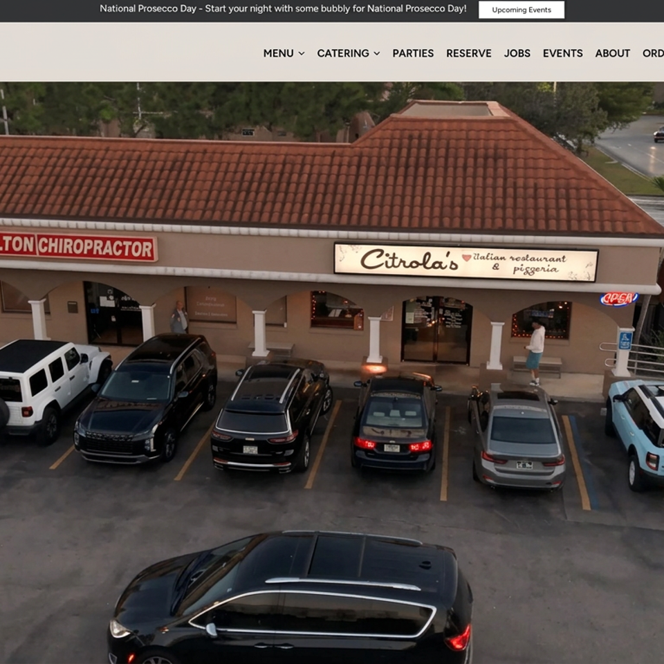 Exterior view of Circlola’s Italian restaurant and pizzeria with tiled roof, parked cars, and a busy roadside.