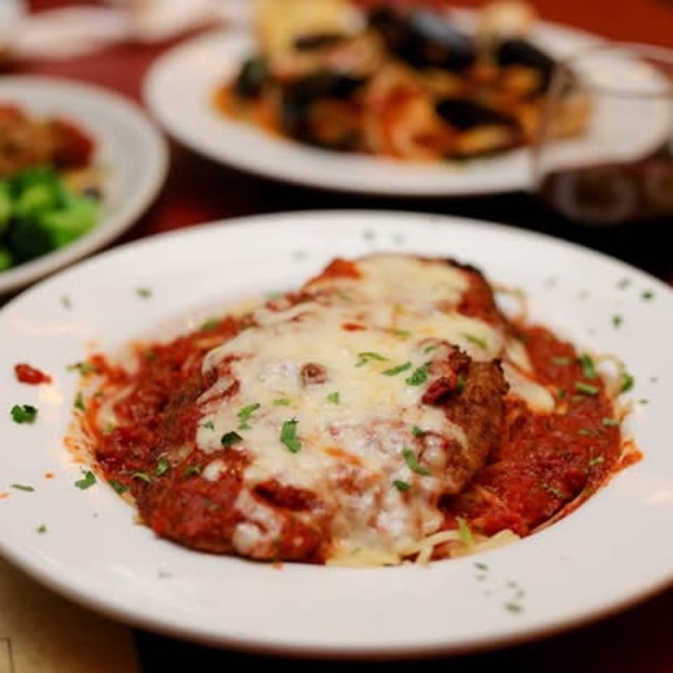 Parmigiana with melted cheese and tomato sauce over spaghetti.